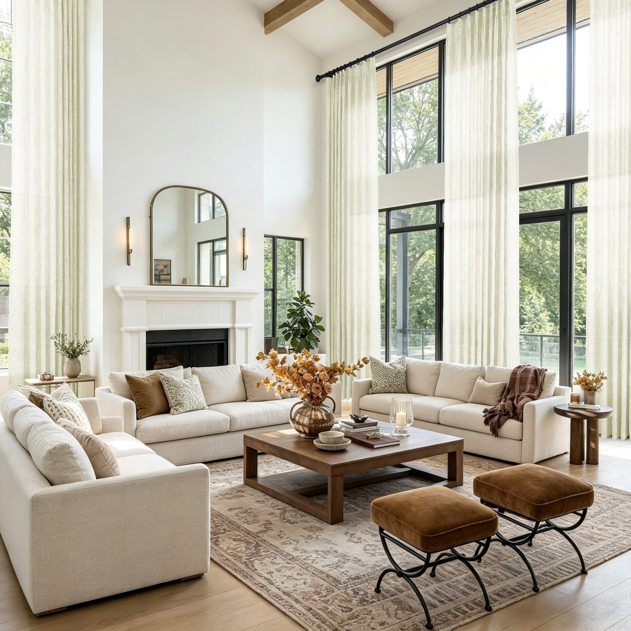 A bright modern living room featuring a large white sectional sofa and tall cream curtains in front of large black framed windows