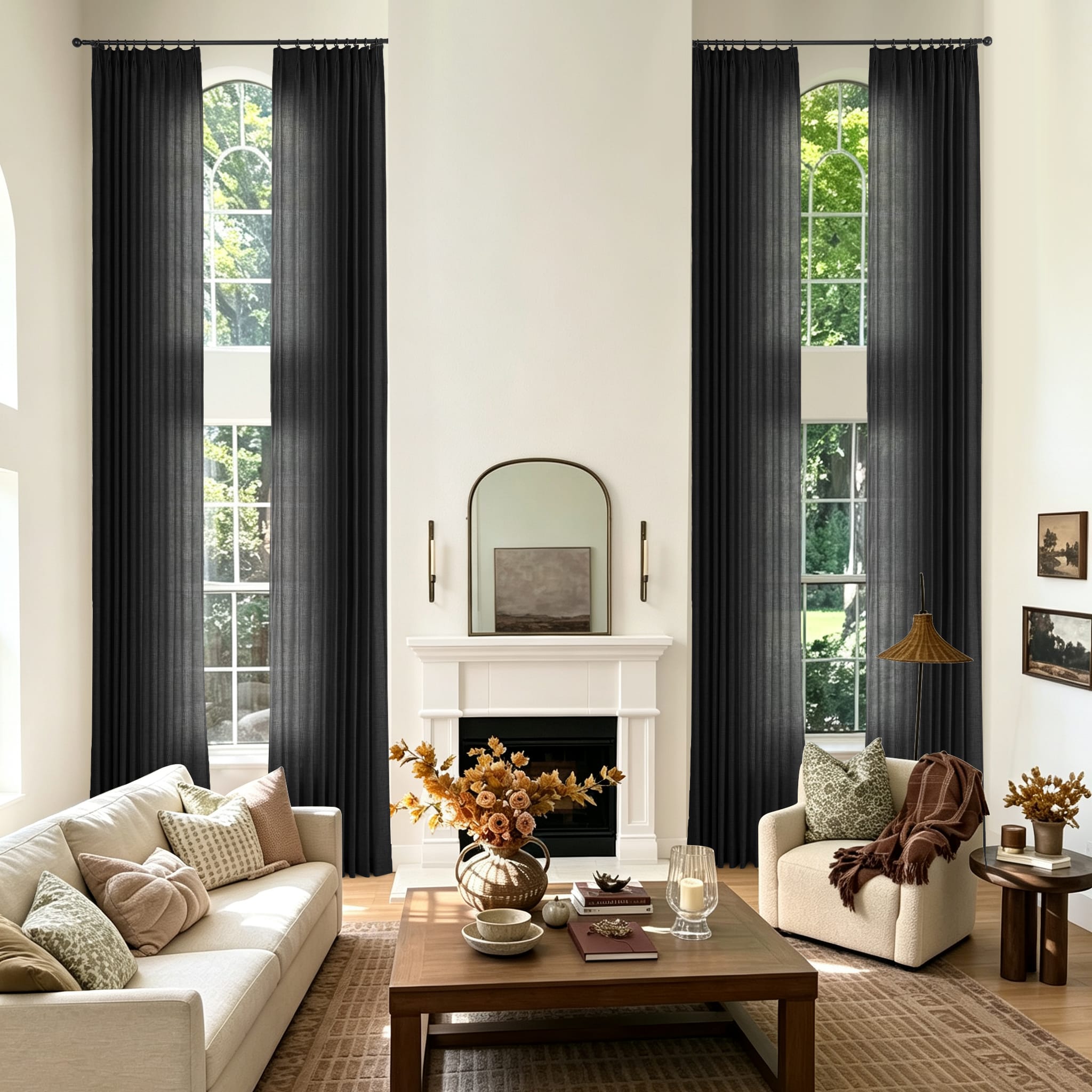 A styled living room with two tall black curtain panels hanging on either side of large arched windows