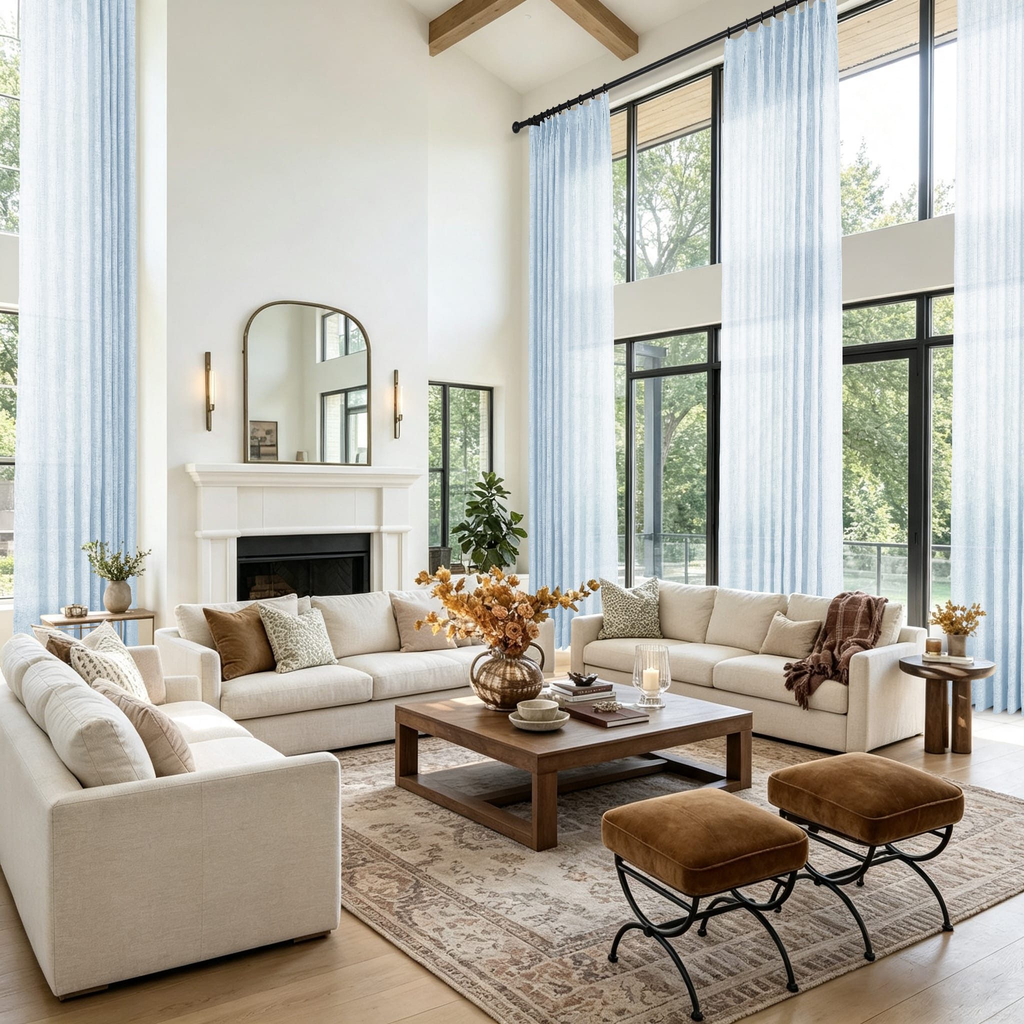 A bright modern living room with a large cream sectional sofa and light blue sheer curtains hanging in tall windows