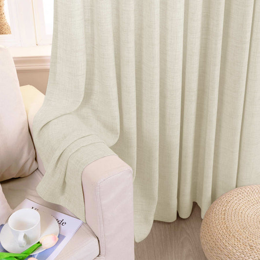 Cream linen textured curtains hanging beside a sofa seat and floor